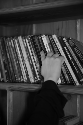 A hand searching among DVD shelf